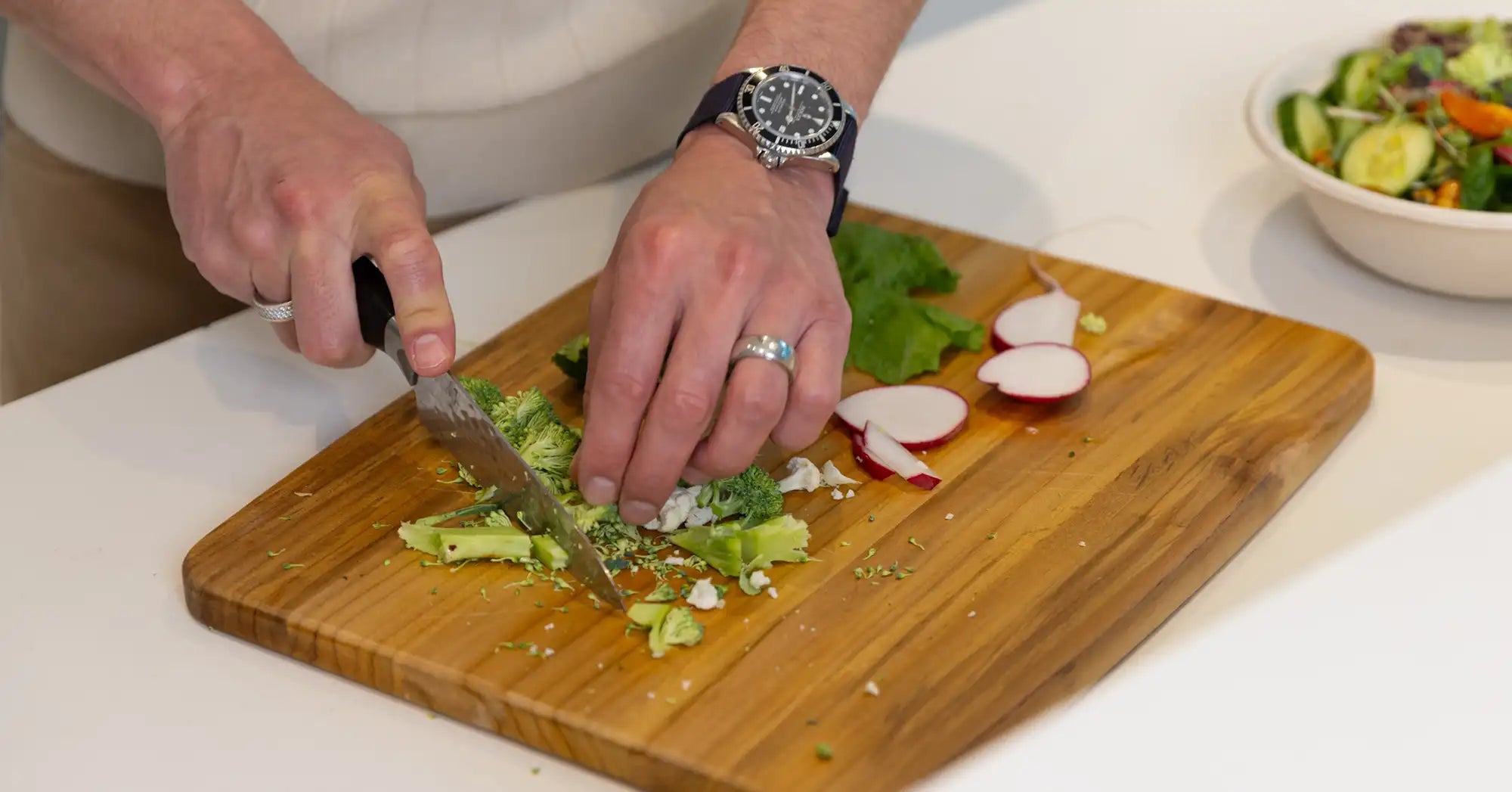 Person preparing a healthy vegetable-rich meal with broccoli, leafy greens, and radishes to support blood sugar balance, insulin sensitivity, glucose metabolism, and long-term metabolic health.