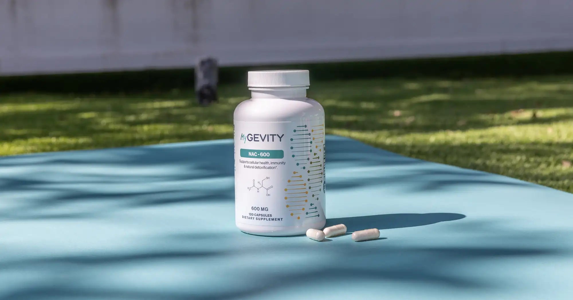 MyGevity NAC-600 supplement bottle displayed outdoors with capsules beside it.