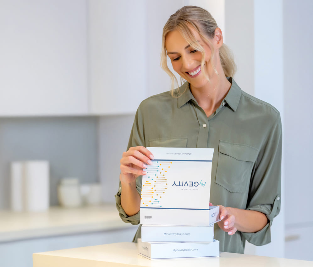 Woman holding a stack of MyGevity test kits