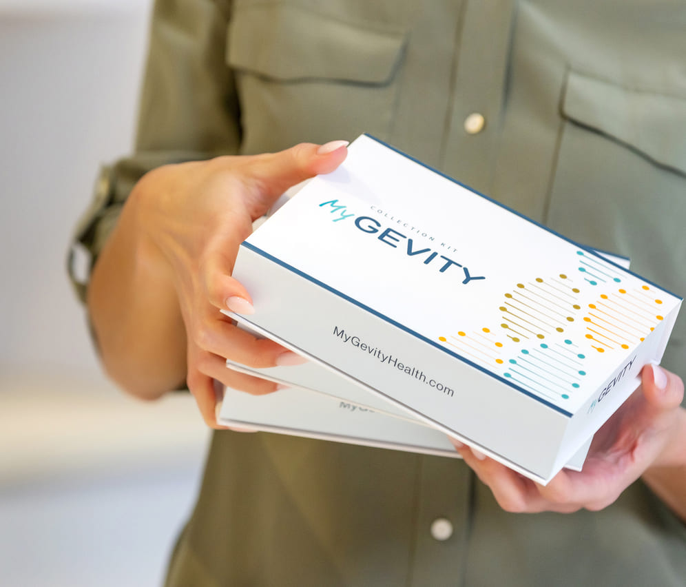 Woman holding multiple MyGevity test kits