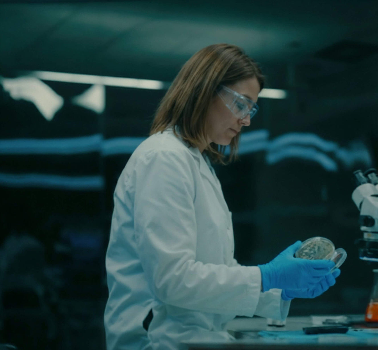 Person in a lab coat holding sample